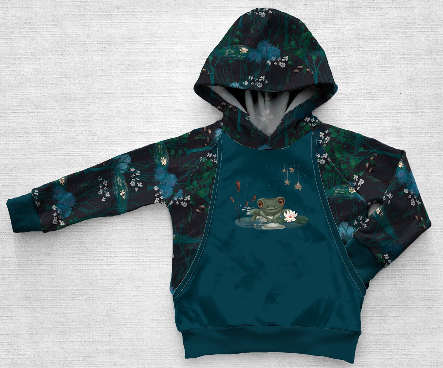 A dark blue hoodie of a frog in a forest frog pond at night
